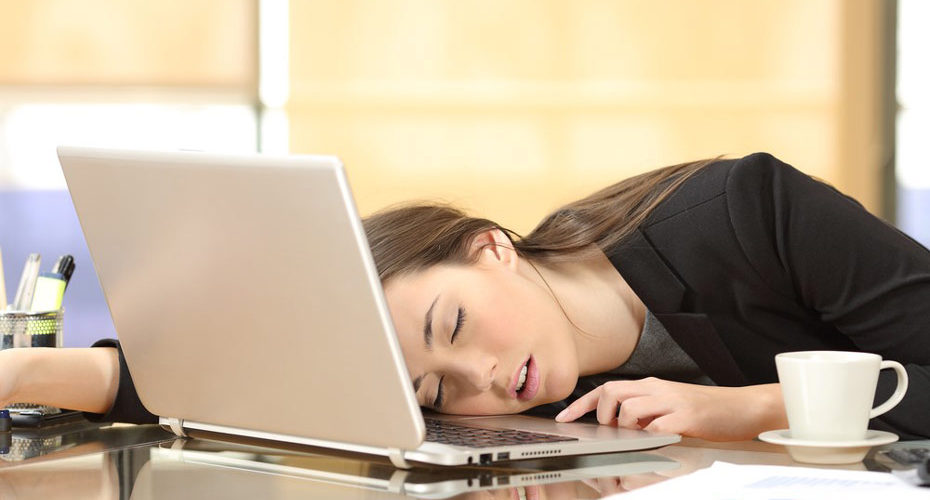 „Uzależniona od snu” kobieta śpiąca przy stole – na swoim laptopie - zdrowy-sen.eu