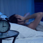 Cierpiąca na bezsenność kobieta w łóżku, która o trzeciej nad ranem ma kłopot z zaśnięciem - zdrowy-sen.eu