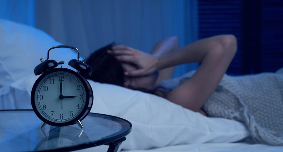 Cierpiąca na bezsenność kobieta w łóżku, która o trzeciej nad ranem ma kłopot z zaśnięciem - zdrowy-sen.eu