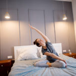Kobieta praktykuje jogę w łóżku przed zaśnięciem – zdrowy-sen.eu
