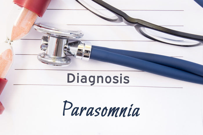 Atrybuty lekarza ułożone na kartce z napisem „diagnoza: parasomnia” – zdrowy-sen.eu