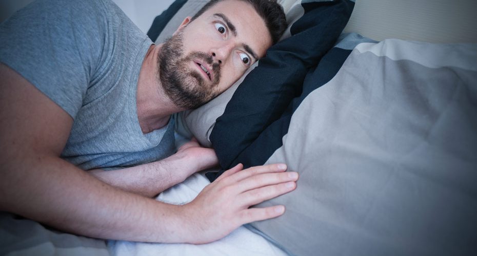 Mężczyzna w łóżku cierpiący na somnifobię – zdrowy-sen.eu